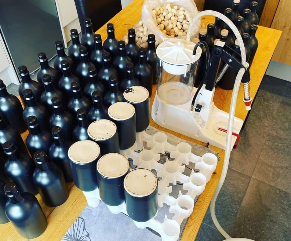 Flessen klaarzetten in het bottelrek naast de Enolmatic-vulmachine
